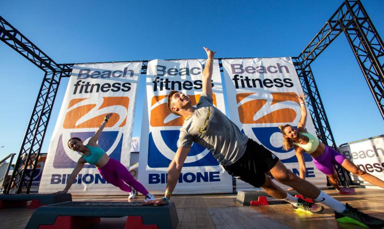 Fitness-Training am Strand mit Trainern und Teilnehmern.