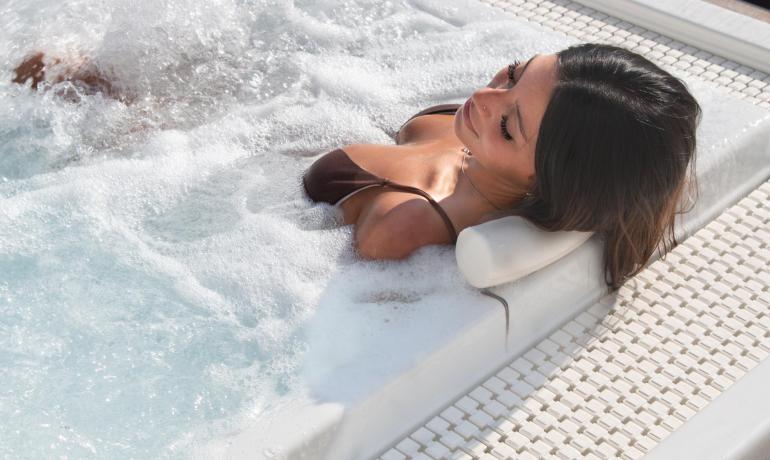 Frau entspannt im Außenwhirlpool.