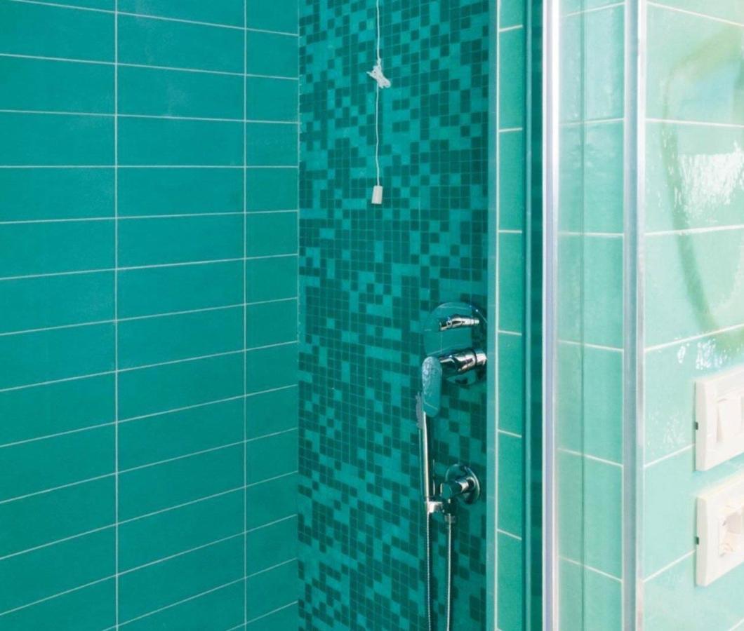 Doccia con piastrelle verdi e mosaico, design moderno.