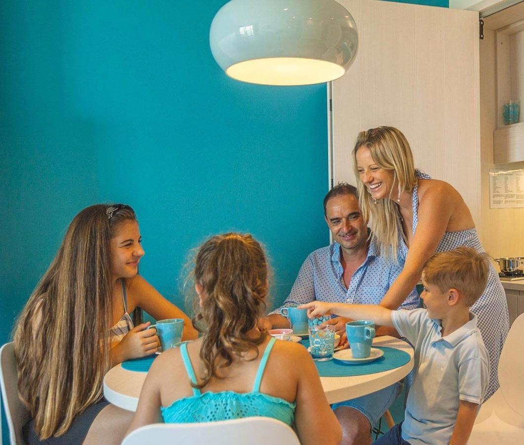 Famiglia felice seduta a tavola in cucina moderna.