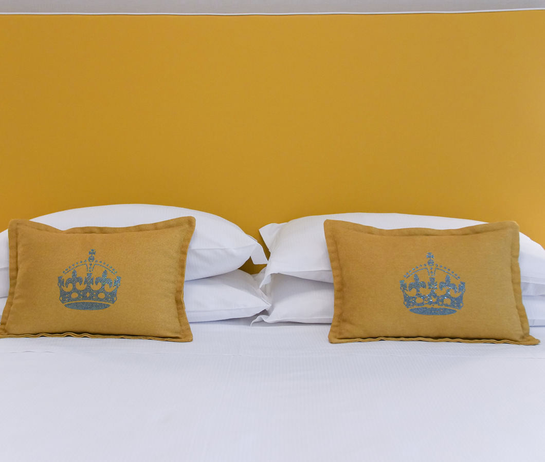 Camera da letto accogliente con cuscini gialli e testo 'nuovo stile in arrivo'.