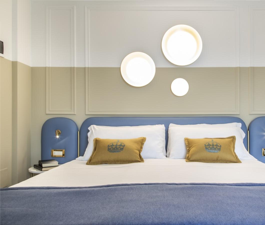 Camera moderna con letto matrimoniale e luci decorative.