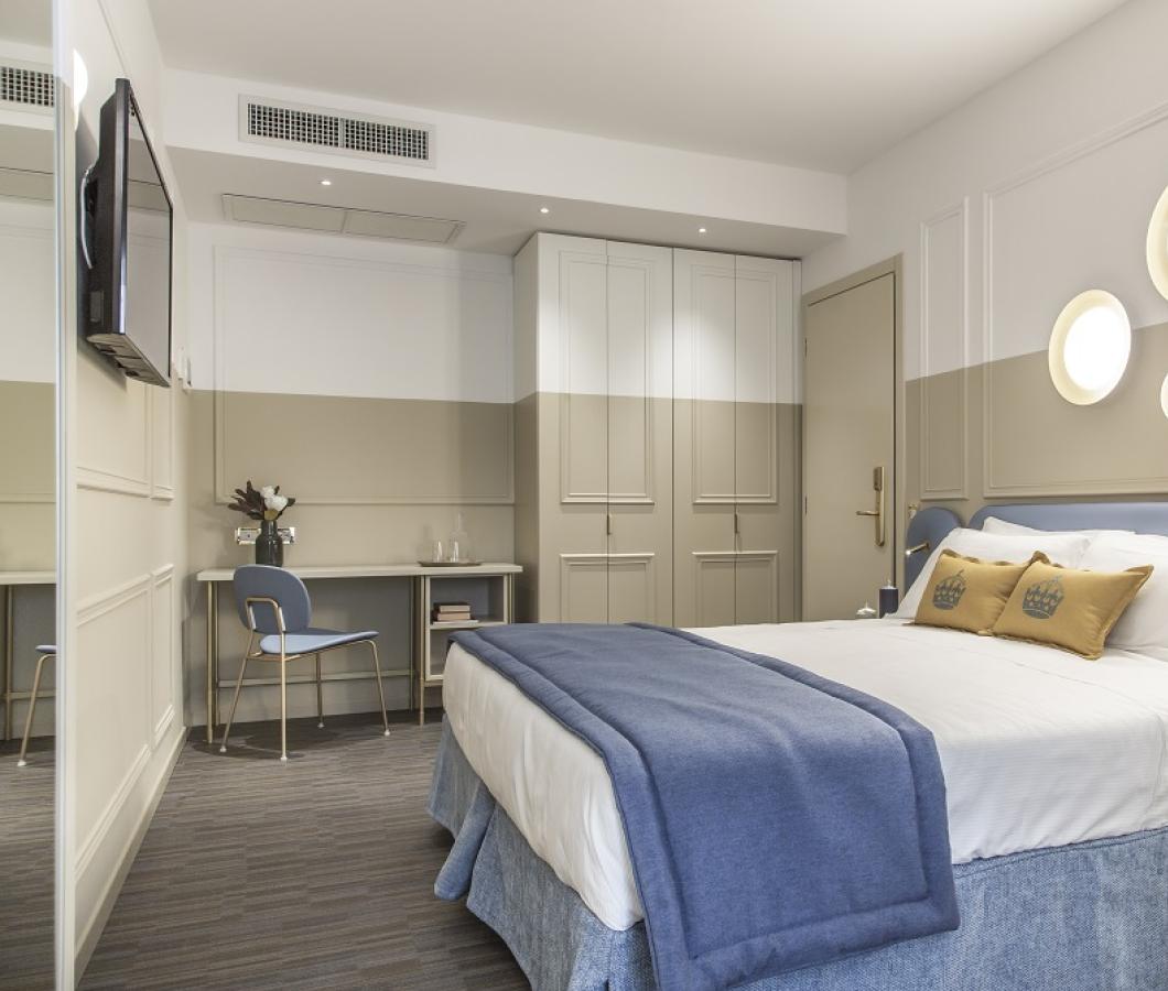 Camera moderna con letto matrimoniale, decorazioni circolari, scrivania e TV.