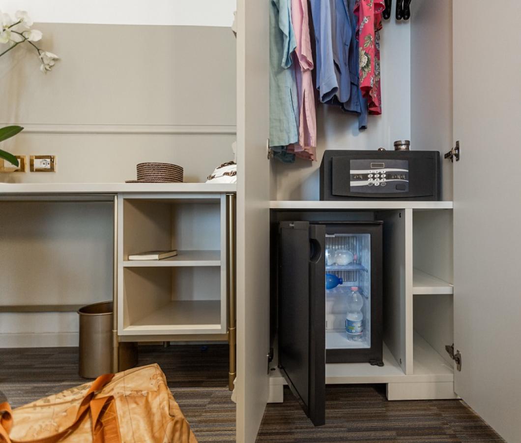 Armadio con cassaforte e minibar in una stanza d'albergo.