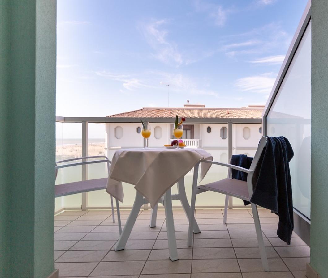 Balcone con tavolo apparecchiato e vista mare.