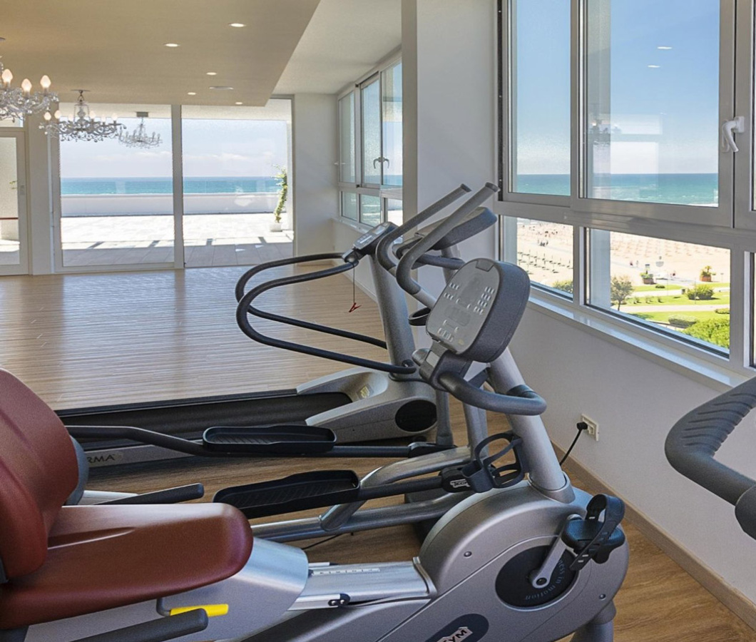 Fitnessstudio mit Meerblick, moderne Geräte.