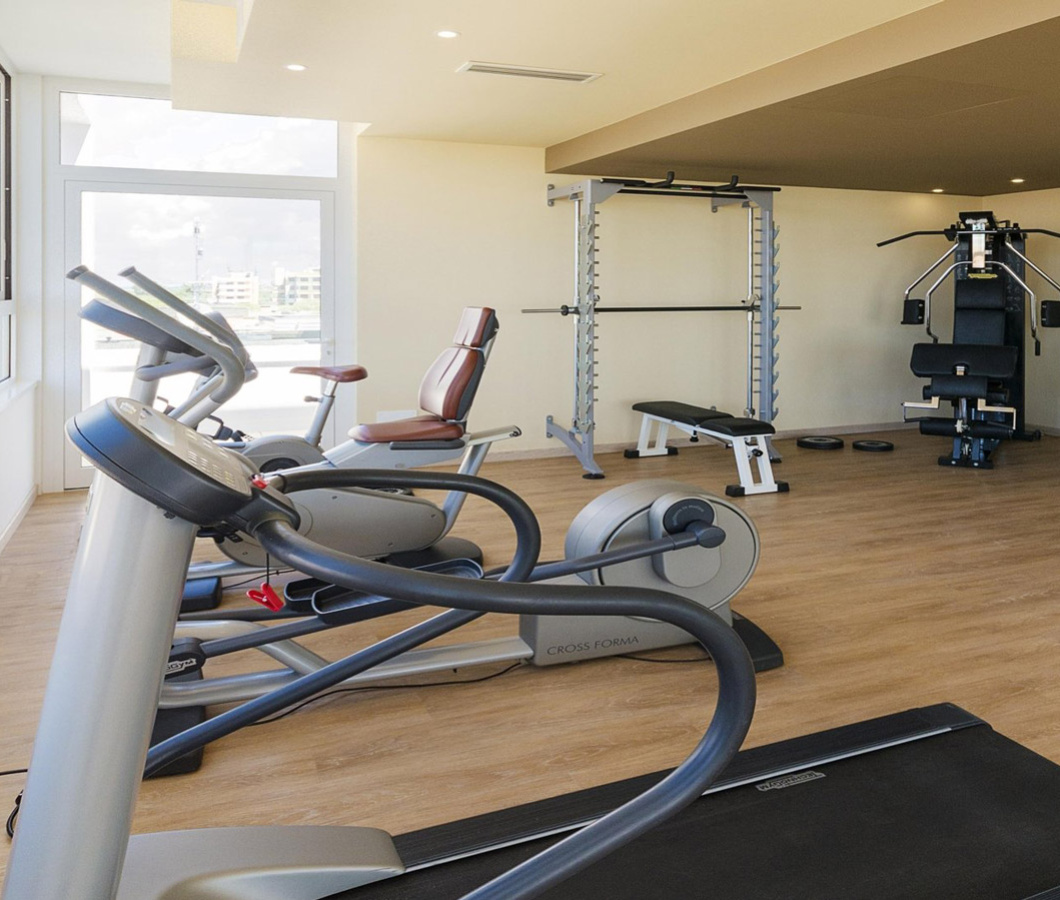 Moderne Fitnessstudio mit Kardio-Geräten und Gewichten.