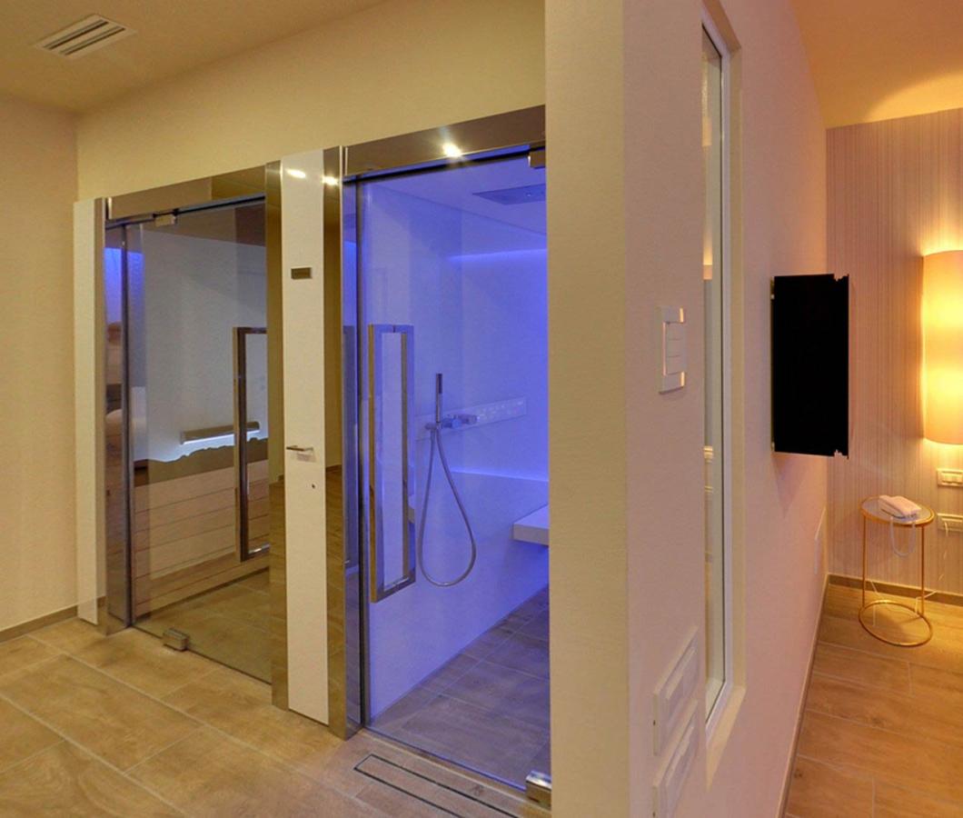 Camera moderna con doccia illuminata e letto accogliente.