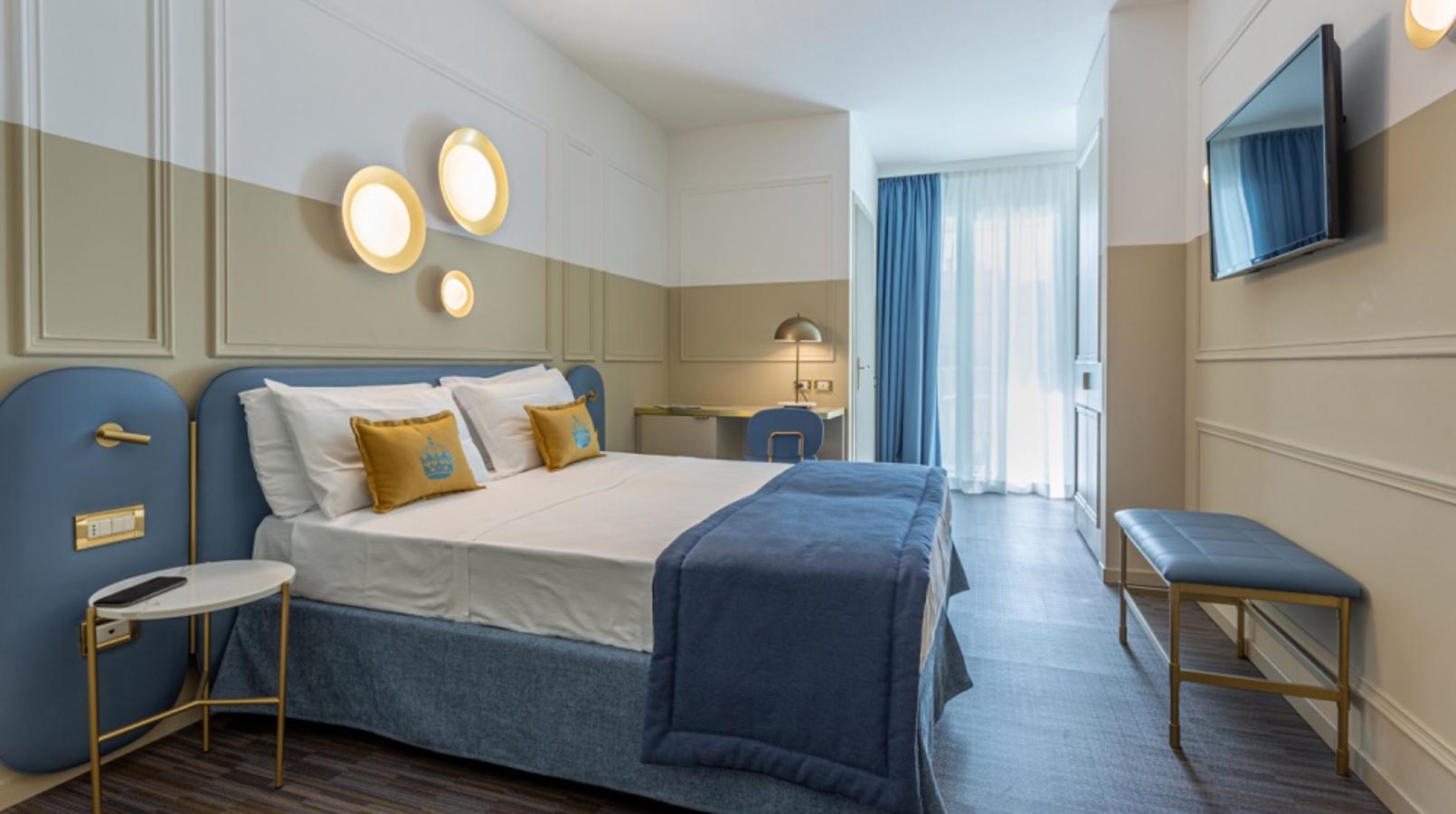 Camera moderna con letto matrimoniale, TV e arredi eleganti.