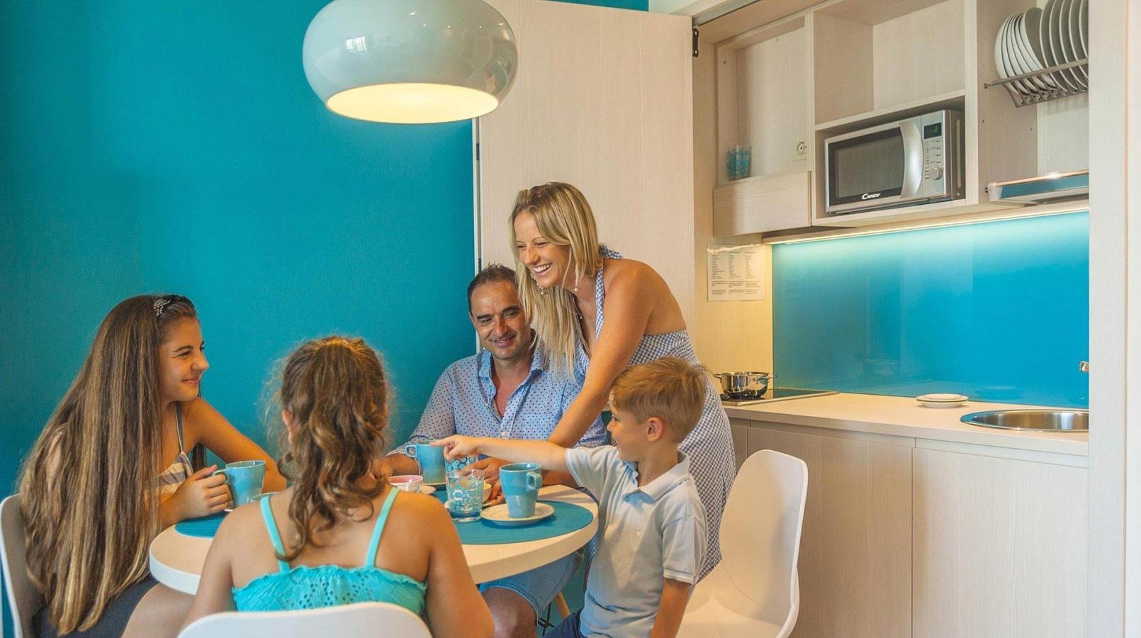 Famiglia felice a tavola in una cucina moderna e luminosa.