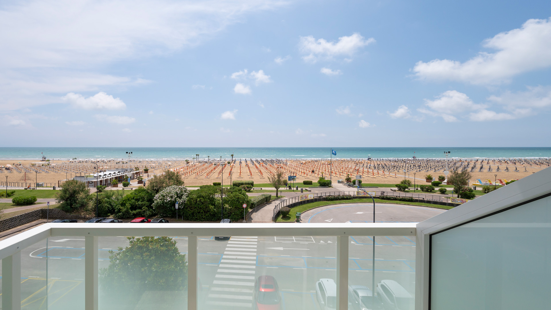 Vista mare con spiaggia, ombrelloni e cielo sereno.