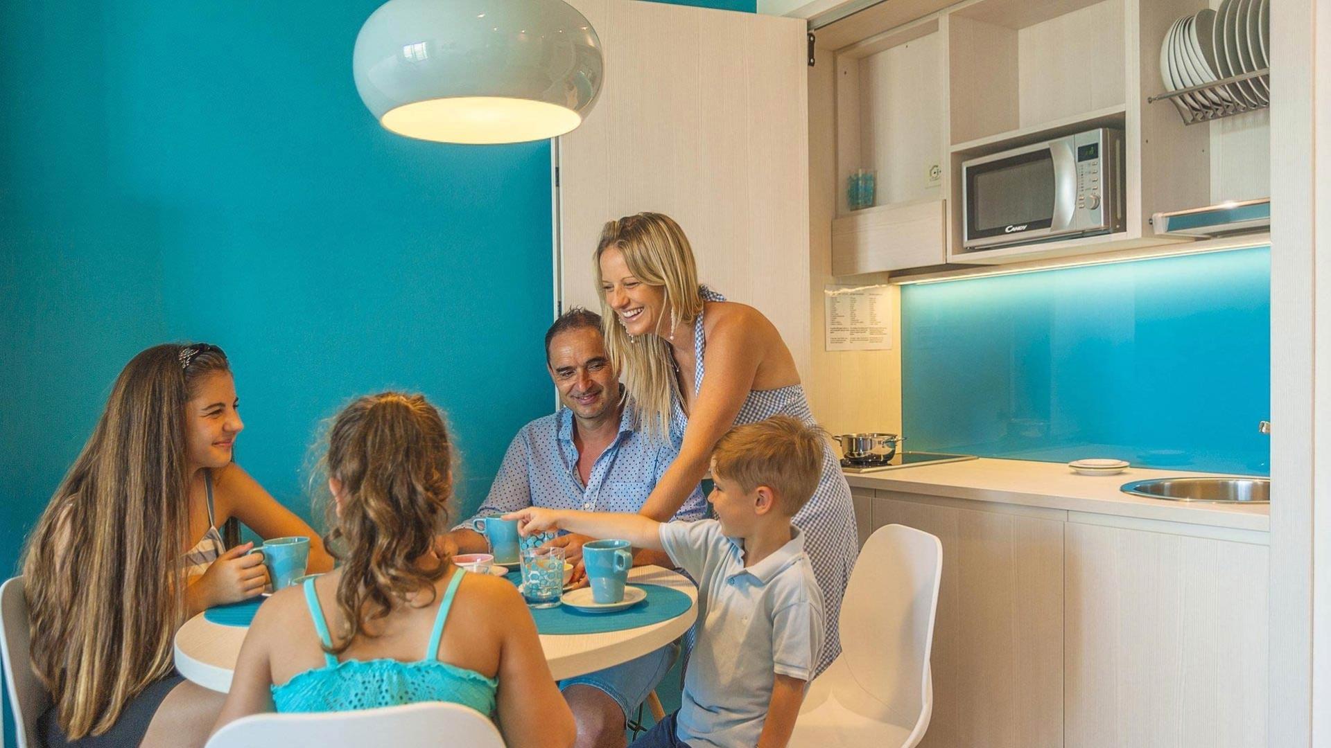 Happy family at the table in a modern, bright kitchen.