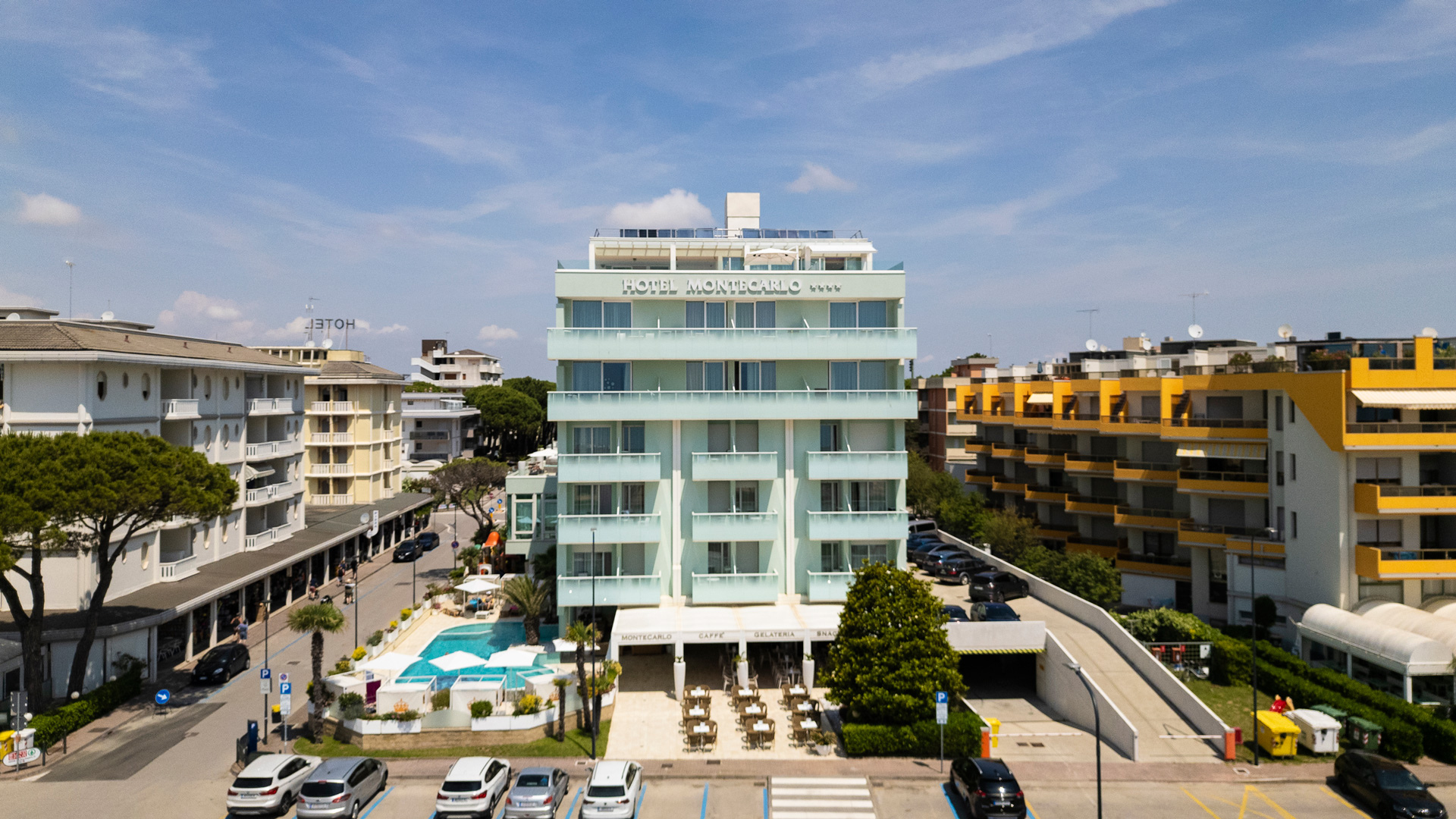 Hotel Montecarlo con piscina, circondato da edifici moderni.
