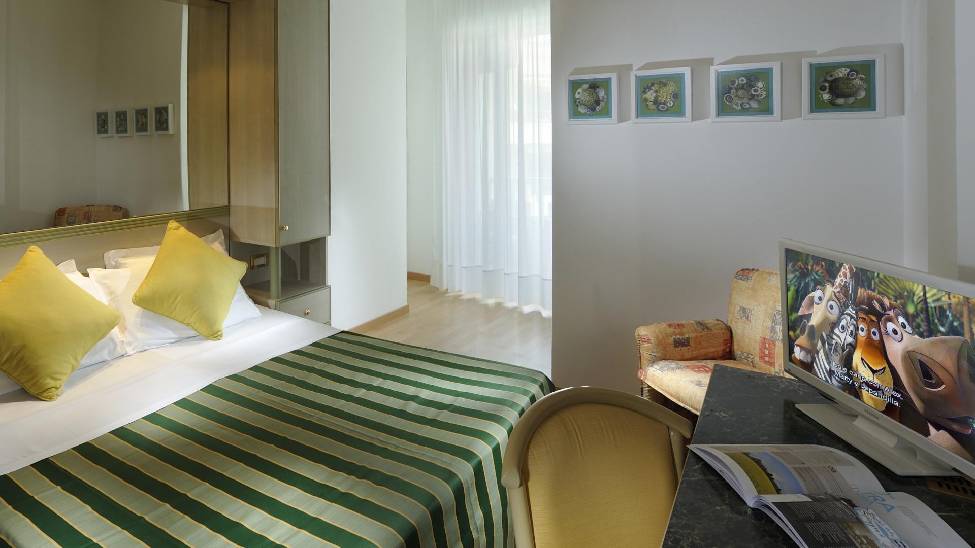 Schlafzimmer mit TV, Bett und moderner Dekoration.