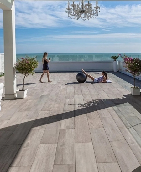 Terrasse am Meer mit weißen Möbeln und Pflanzen.