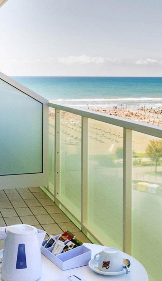 Balcone con vista mare, tavolino con tazza e bollitore.
