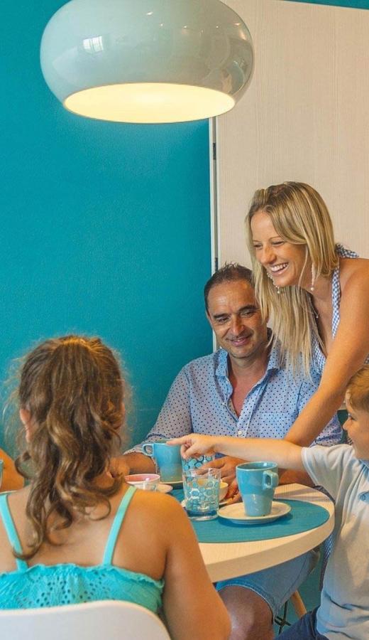 Famiglia felice a tavola in una cucina moderna e luminosa.
