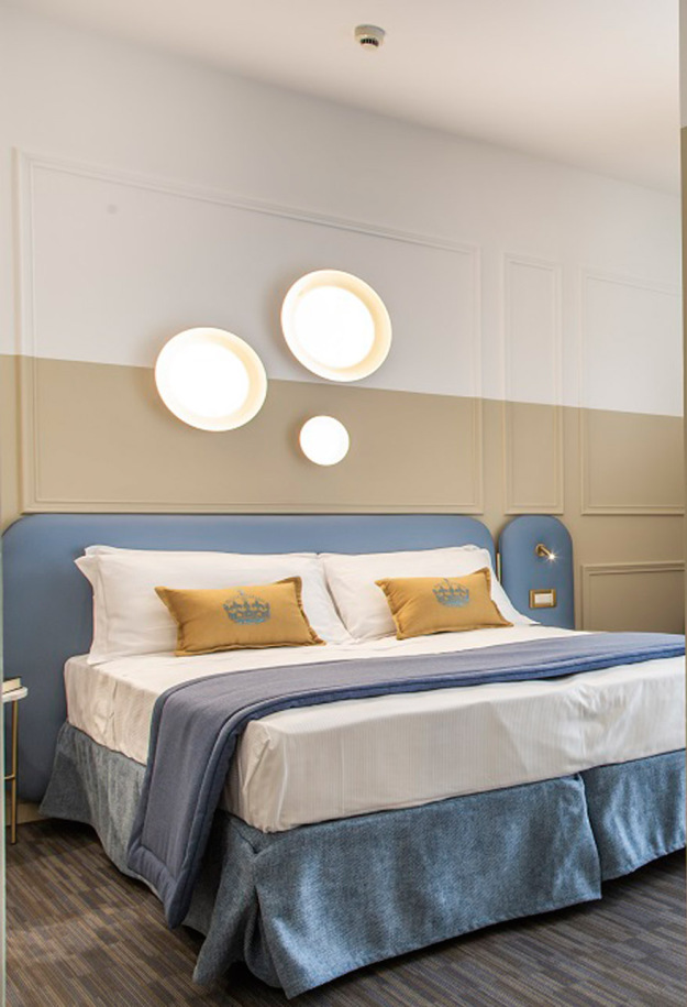 Modern room with double bed, TV, and desk.