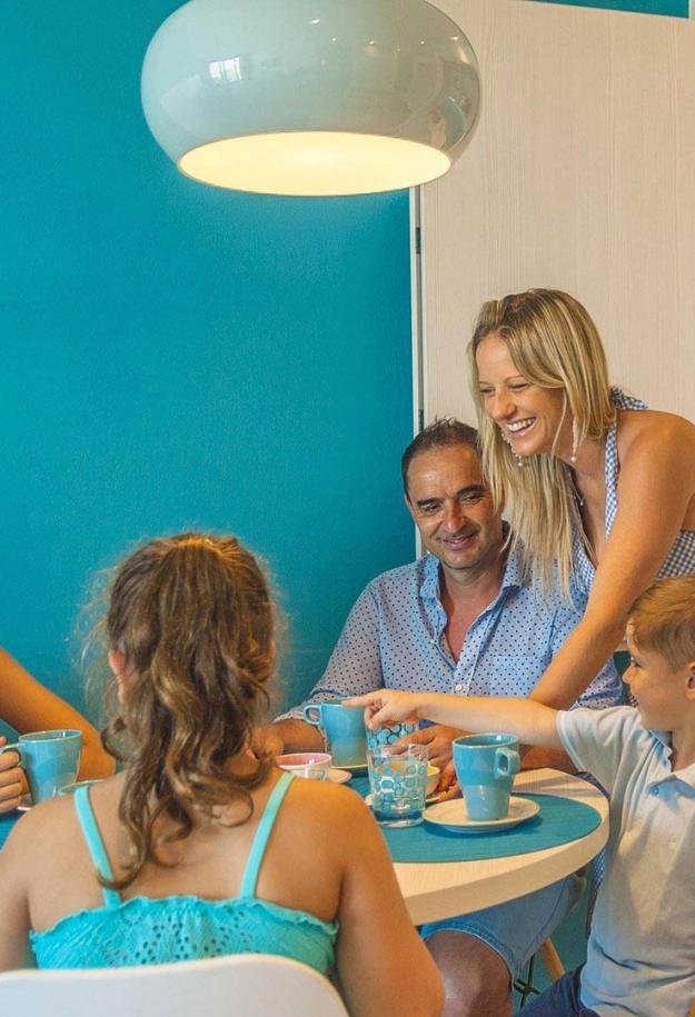 Famiglia felice a tavola in una cucina moderna e luminosa.