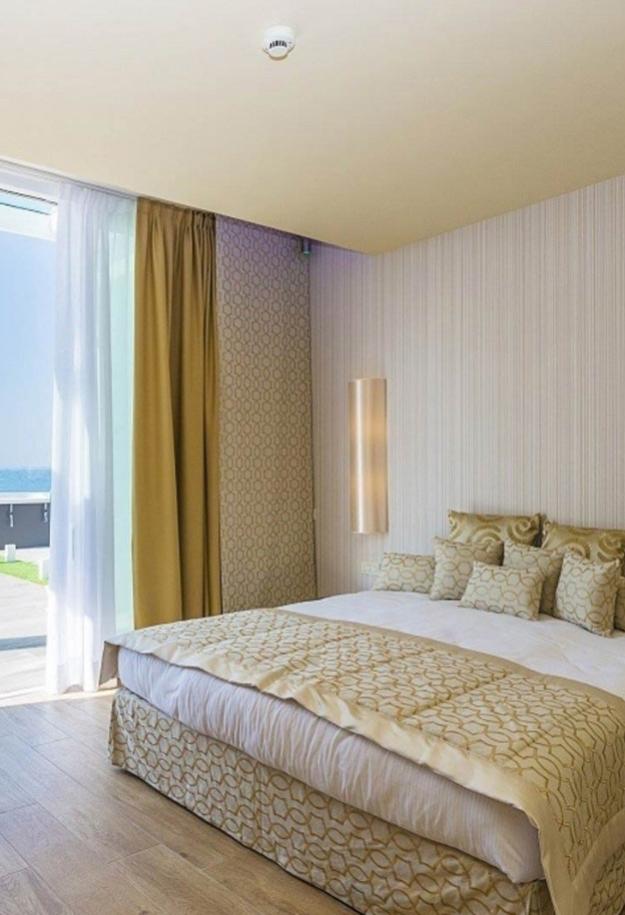 Camera moderna con letto matrimoniale e vista mare.
