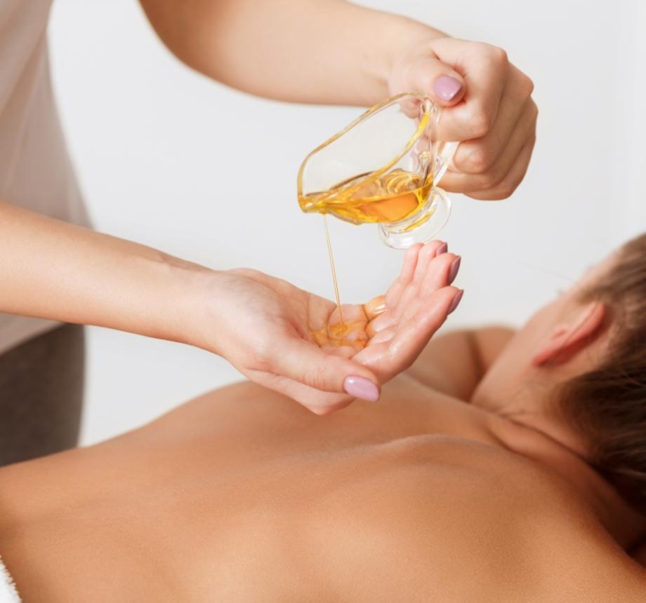Olio da massaggio versato su mani per terapia rilassante.
