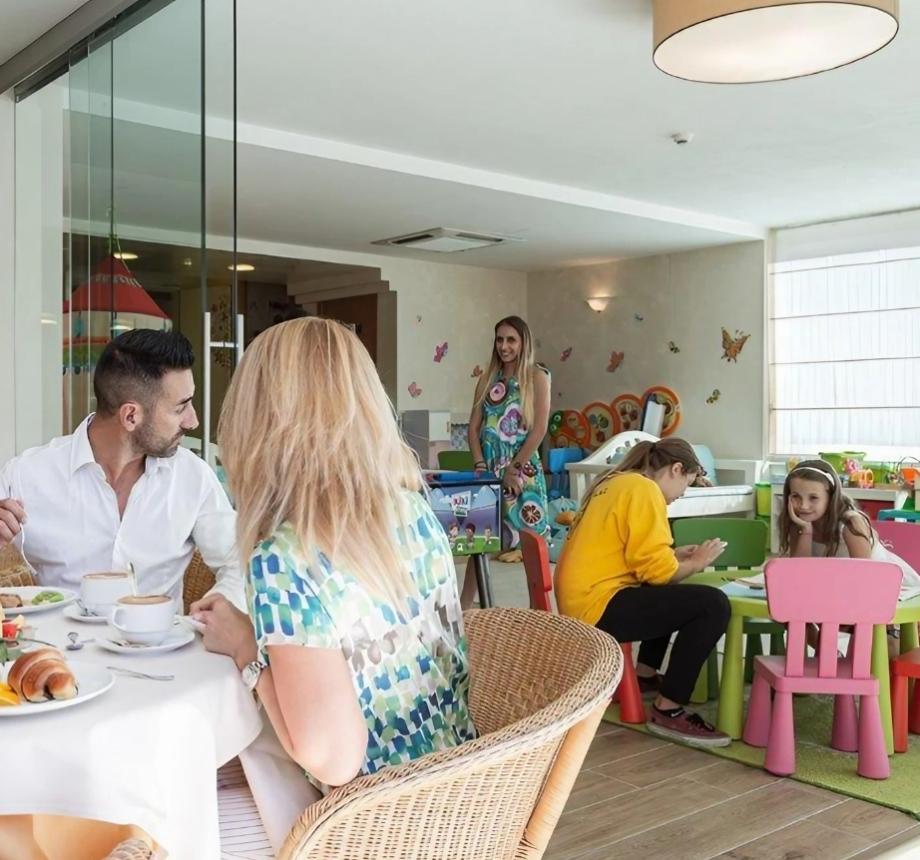 Family having breakfast near a children's play area.