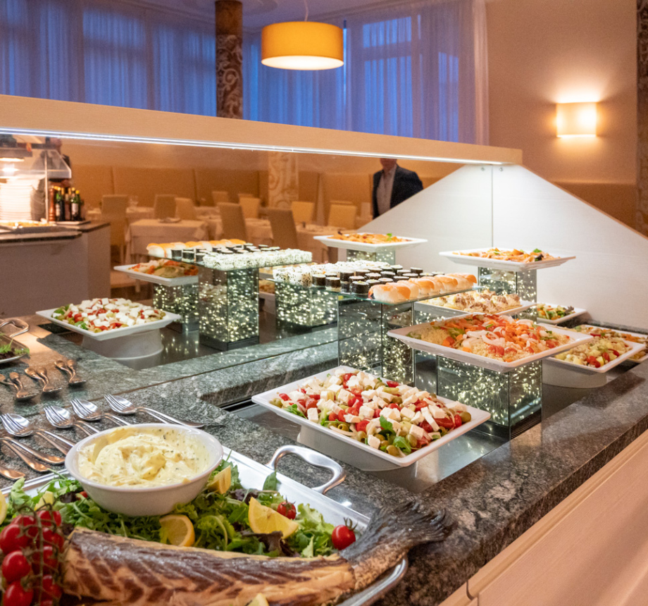 Buffet elegante con insalate, pesce e piatti vari in un ristorante raffinato.